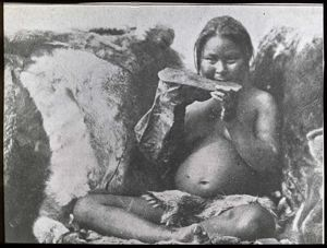 Image of Woman chewing sealskin for boot sole 